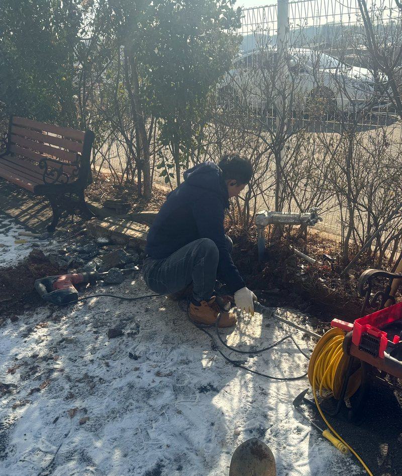 건물 바깥 마당 흙을 걷어내고 묻힌 배관을 찾는 굴착 작업