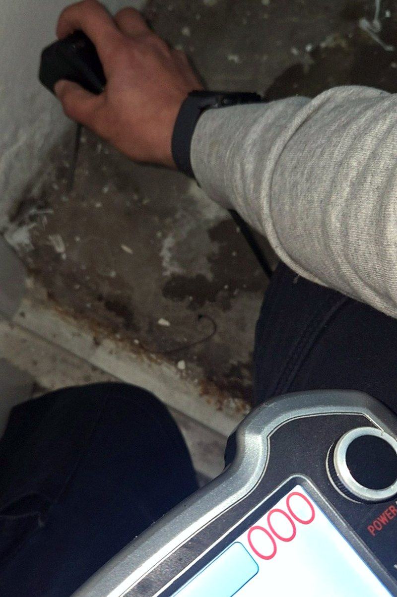 벽면에 누수 탐지기를 대어 반응을 확인하는 모습
