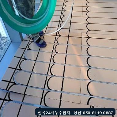 건식난방 패널 홈을 따라 온수 호스를 넣는 작업