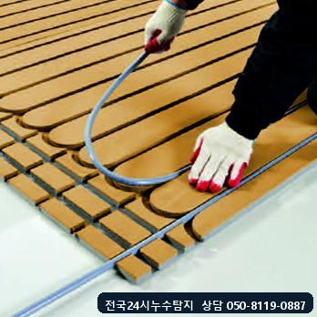난방배관 교체용 온수 호스를 패널 홈에 끼우는 모습