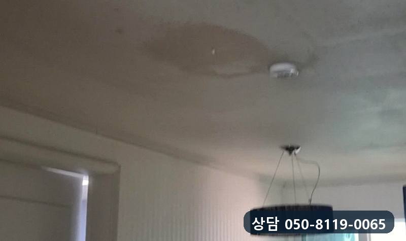 난방관에서 샌 물로 아래층 거실 천장에 누런 얼룩이 번진 모습