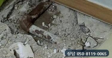 바닥을 열자 드러난 오래된 강관 엘보에 붉은 녹이 두껍게 앉은 모습