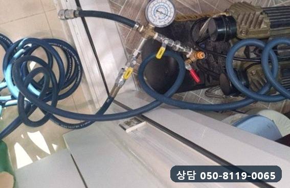 바닥에 놓고 배관에 호스를 연결한 컴프레서와 압력계