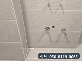 연 자리를 메우고 타일을 다시 붙인 세면대 자리 벽