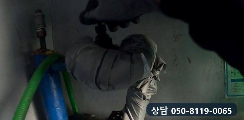 보온재로 감싼 배관 밸브에 손을 대고 확인하는 모습