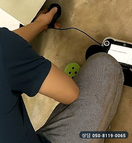 바닥에 청음 센서를 손으로 눌러 대고 옆에 둔 본체로 소리를 확인하는 모습