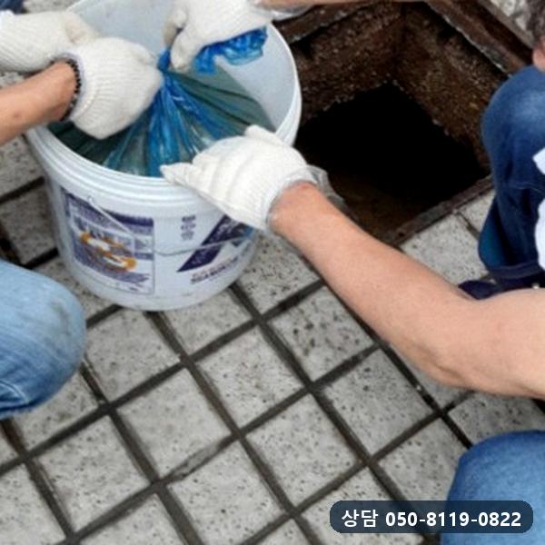 걷어낸 정화조 찌꺼기를 자루에 담는 작업
