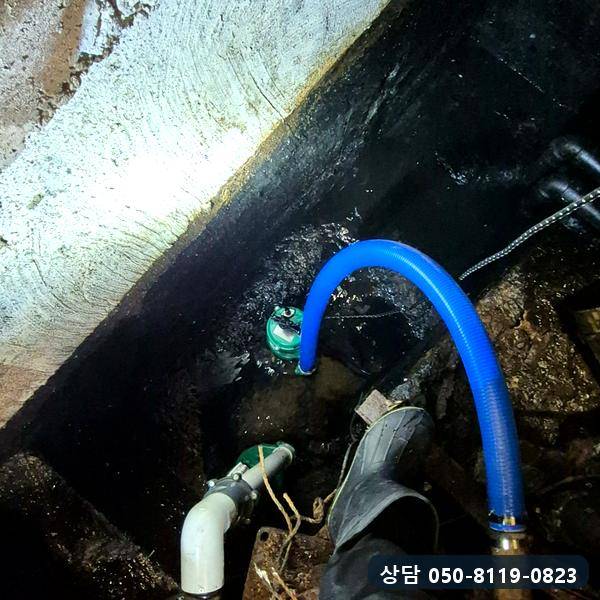집수정 안 펌프에 배출 호스를 연결하는 작업